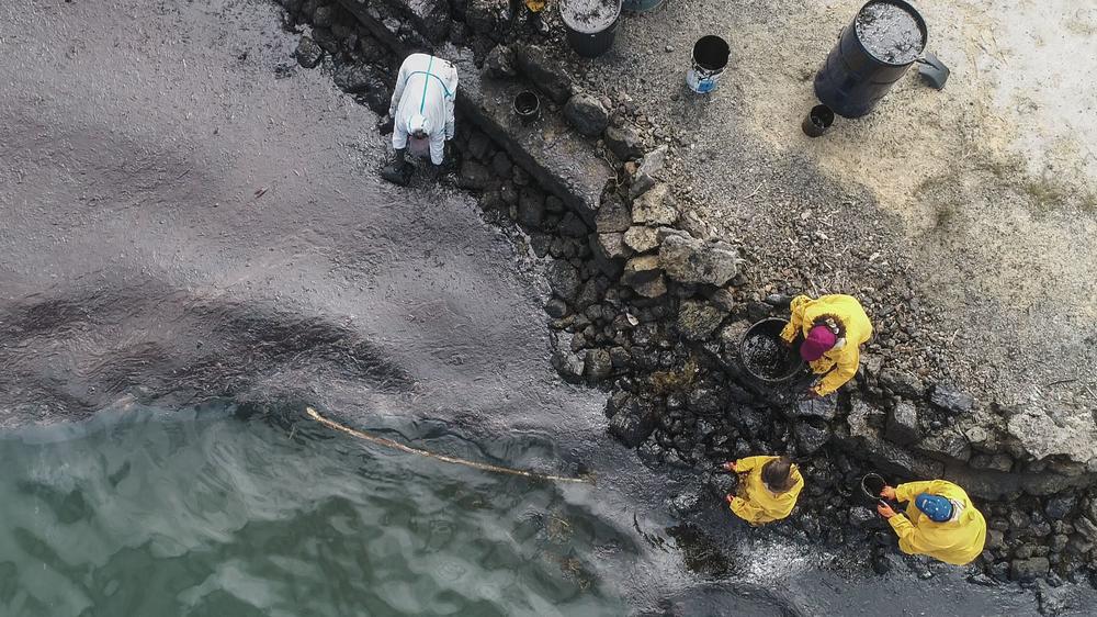 Scooping oil at the beach in Bambous Virieux, in southeast Mauritius, on Saturday.