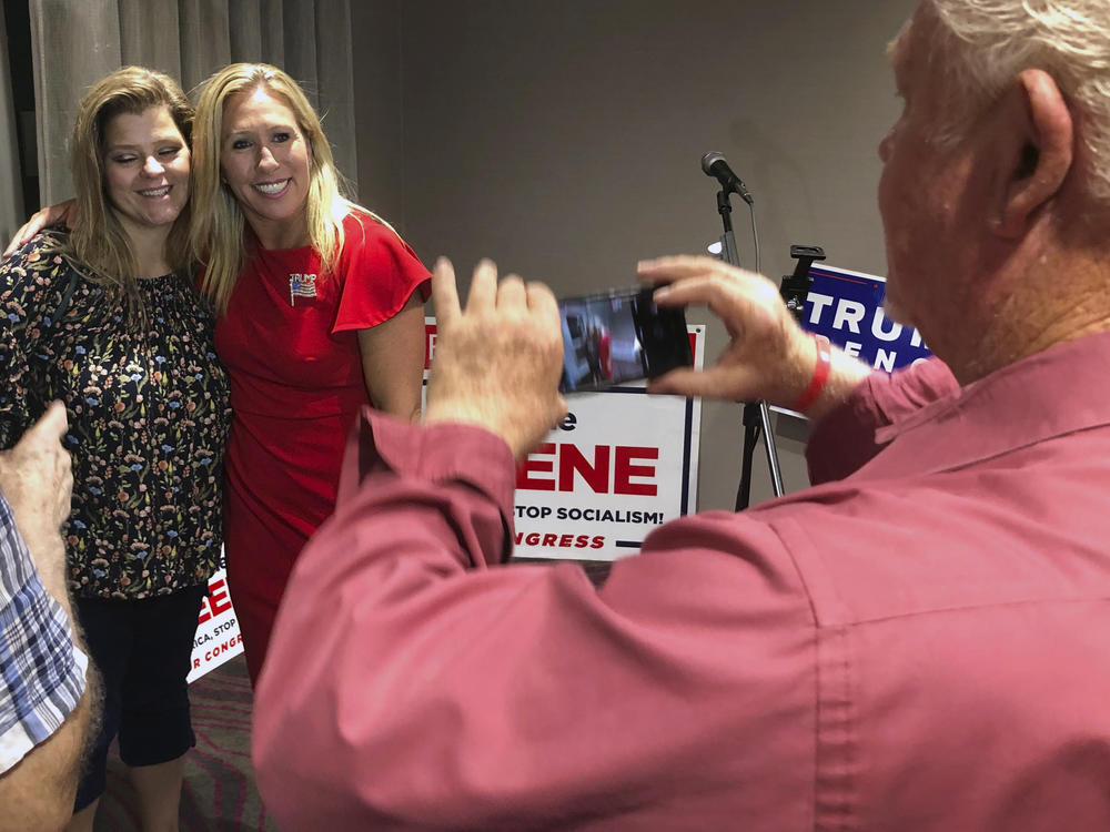 Marjorie Taylor Greene (right) is likely to bring a far-right conspiracy theory to the House of Representatives next year.