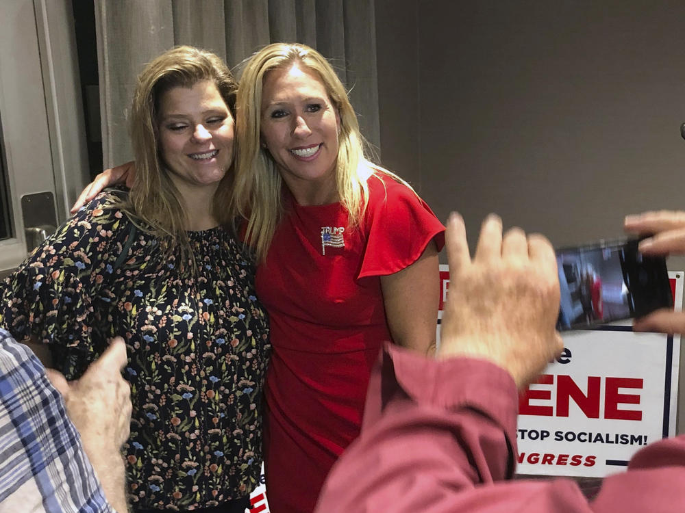 Marjorie Taylor Greene (right) poses with a supporter in Rome, Ga., late Tuesday. Greene, criticized for promoting bigoted videos and supporting the far-right QAnon conspiracy theory, won the GOP nomination for Georgia's 14th Congressional District.