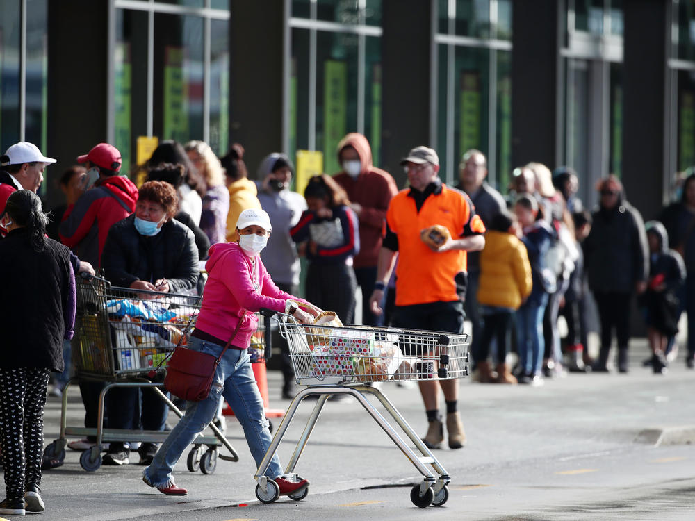 People line up outside a supermarket in a suburb of Auckland, New Zealand, on Wednesday before a three-day lockdown goes into effect. Four new COVID-19 cases were diagnosed in Auckland, and an additional four probable cases have been identified.