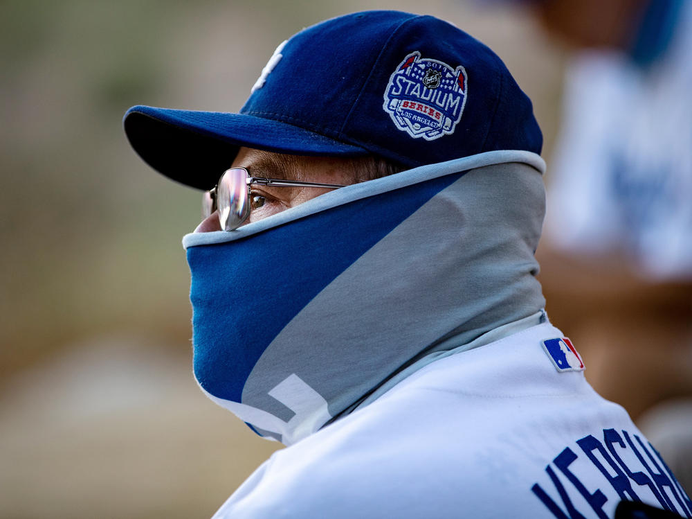 A fan wears a neck gaiter as he watches the Los Angeles Dodgers play at home against the San Francisco Giants last week.