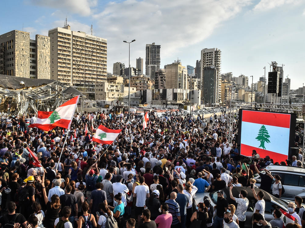 People wave Lebanese flags at a protest near the Beirut port on Tuesday. Last week's explosion has prompted new hopes for political change, but enormous challenges remain.