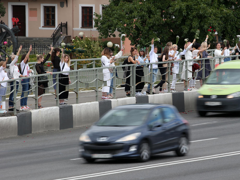Women hold flowers Thursday in support of demonstrators who were injured or detained during protests critical of election results in Belarus.