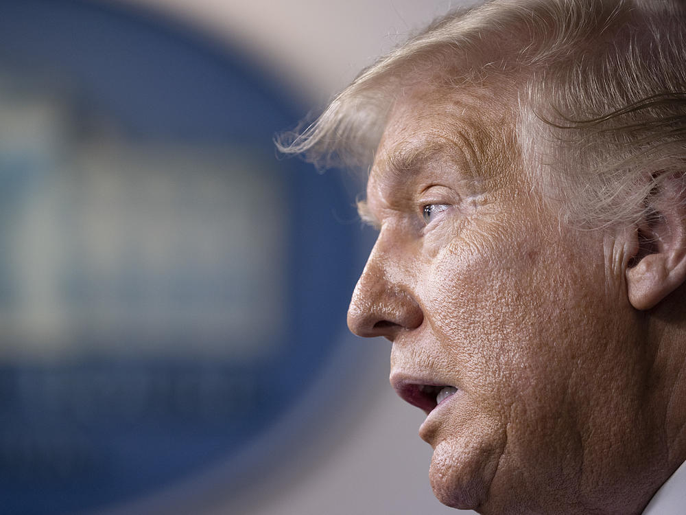 President Trump speaks at a White House briefing Thursday. Earlier he told the Fox Business Network that he plans to block additional funding and election assistance for the U.S. Postal Service to prevent efforts to expand mail-in voting.
