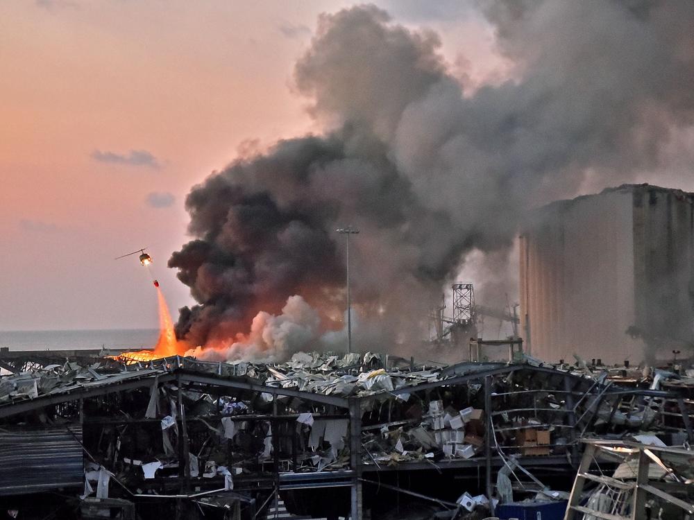 A helicopter puts out a fire at the scene of an explosion at the port of Lebanon's capital Beirut on Aug. 4.
