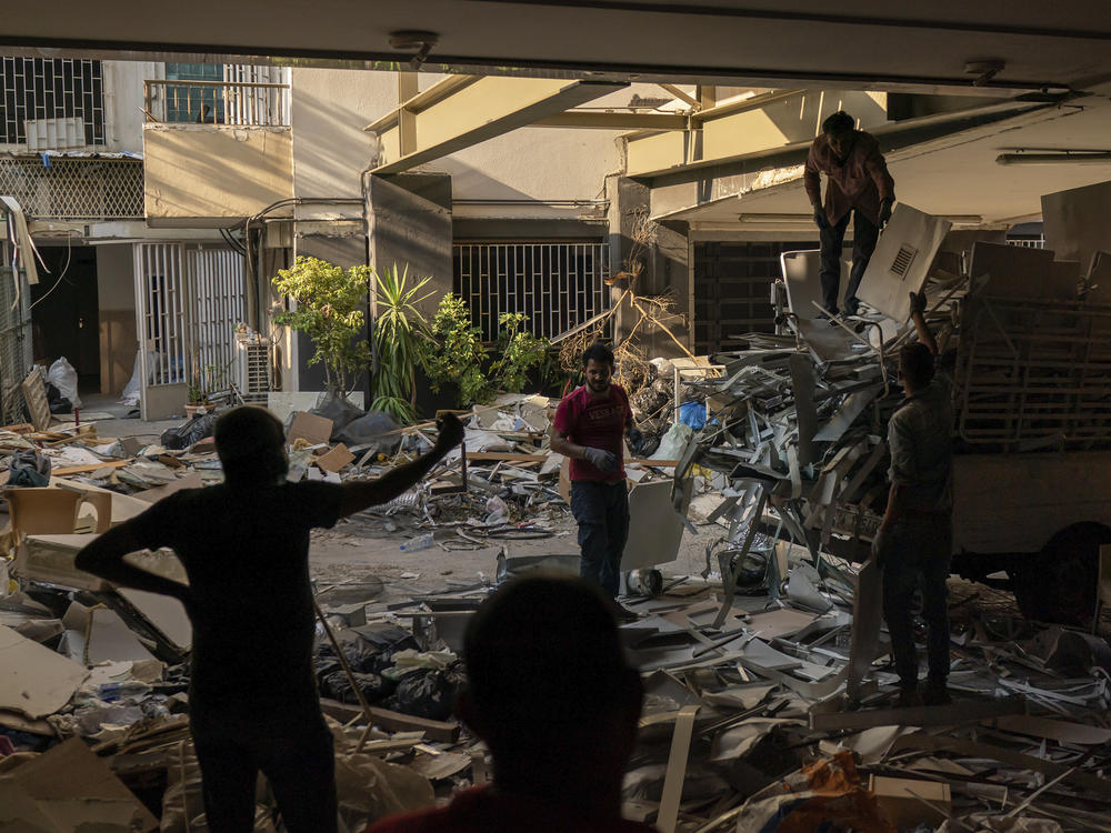 Workers remove debris from a hospital that was heavily damaged in last week's explosion that hit the seaport of Beirut.
