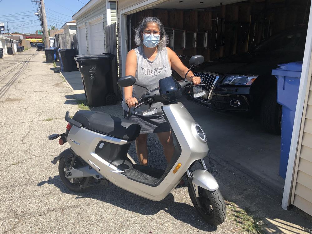 Magali Olson shows her new electric scooter, which she bought a week ago so she doesn't have to commute on the train.