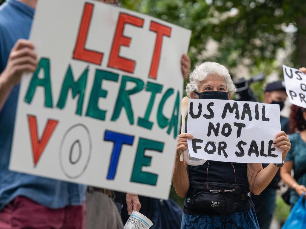 Demonstrators prepare to march Saturday to the home of Postmaster General Louis DeJoy in Washington, D.C.
