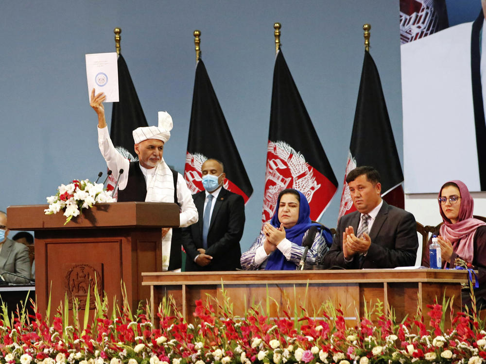 Afghan President Ashraf Ghani holds up a resolution on the last day of a traditional council known as a Loya Jirga, in Kabul, Afghanistan, Aug. 9. The council concluded with hundreds of delegates agreeing to free 400 Taliban members, paving the way for an early start to negotiations between Afghanistan's warring sides.
