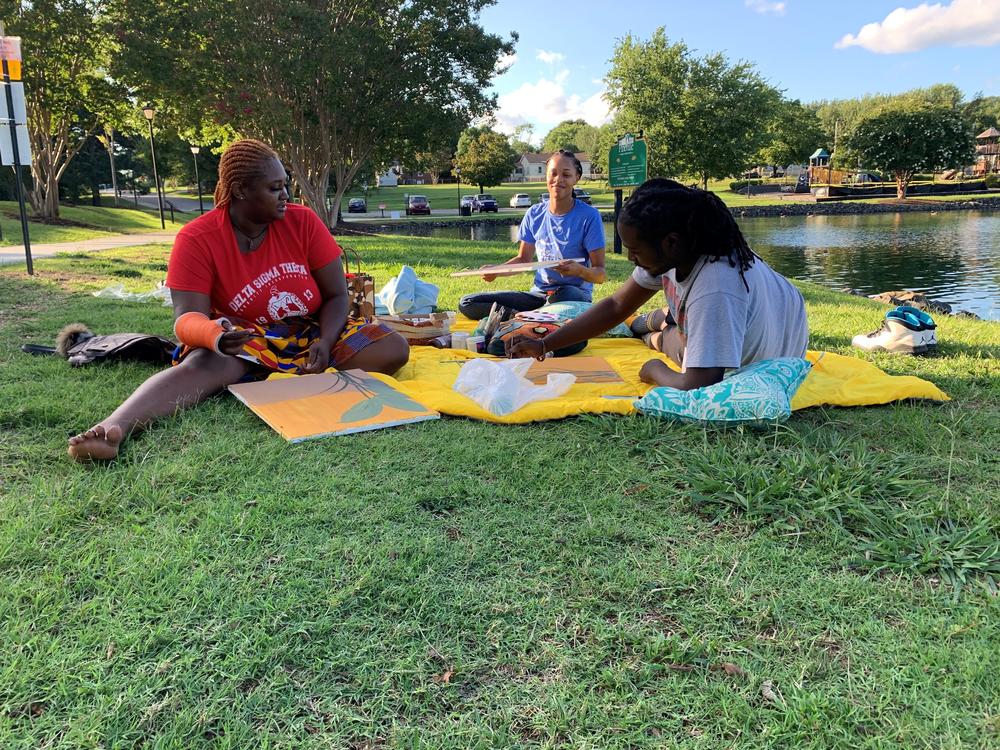 From left to right, Aijah Crockett and Lisa Griffin join their friend visiting from New York, Dom Carter, at Jack D. Hughes Memorial Park in Pineville, N.C. Crockett and Griffin are both Charlotte area residents who are voting for Democrat Joe Biden.
