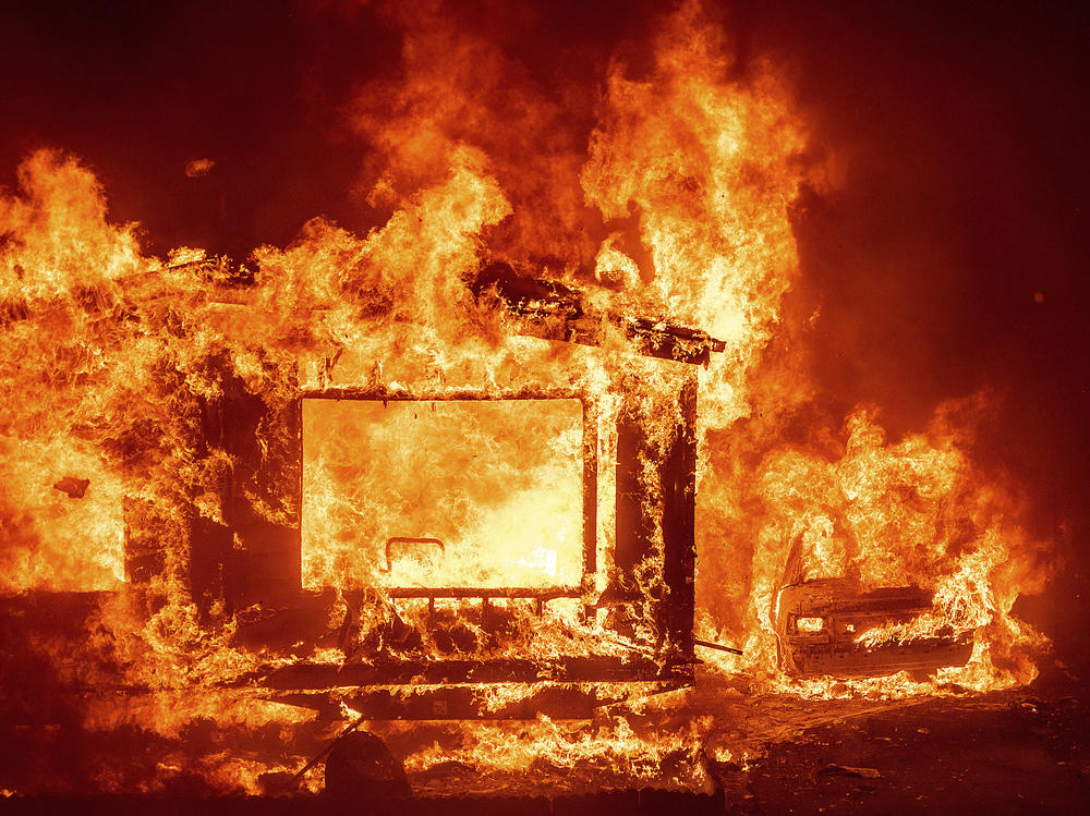 A mobile home and car burn at Spanish Flat Mobile Villa as the LNU Lightning Complex fires tear through unincorporated Napa County, Calif., on Tuesday.