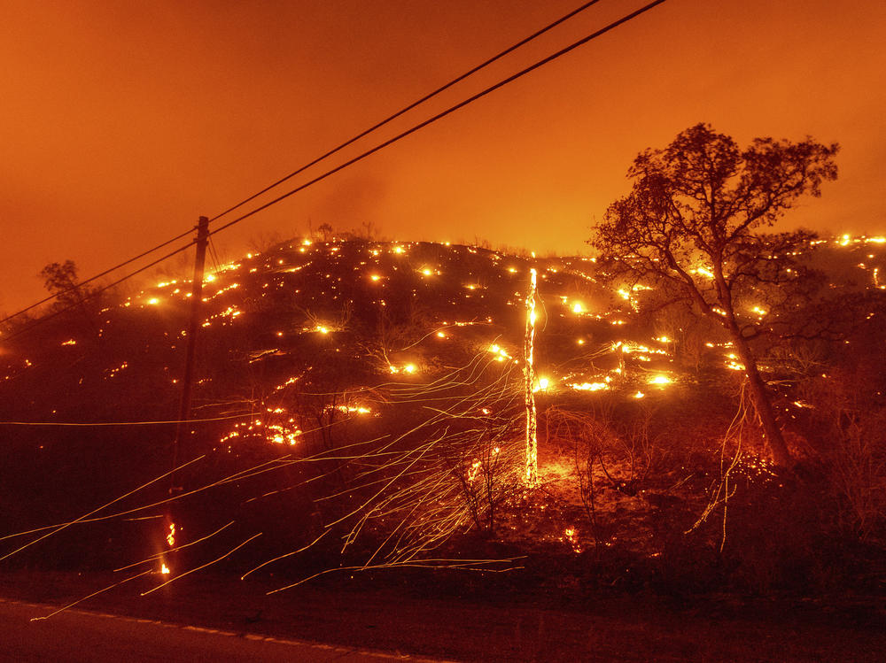 Embers burn along a hillside as the LNU Lightning Complex fires tear through unincorporated Napa County, Calif., on Tuesday. Fire crews across the region scrambled to contain dozens of wildfires sparked by lightning strikes as a statewide heat wave continues.