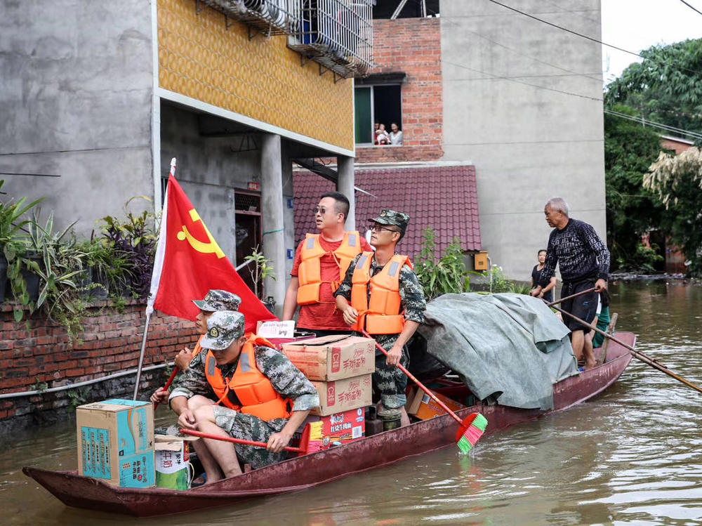Community workers and volunteers deliver food and supplies to flood-affected residents after heavy rains in Neijiang in China's southwestern Sichuan province on Wednesday.