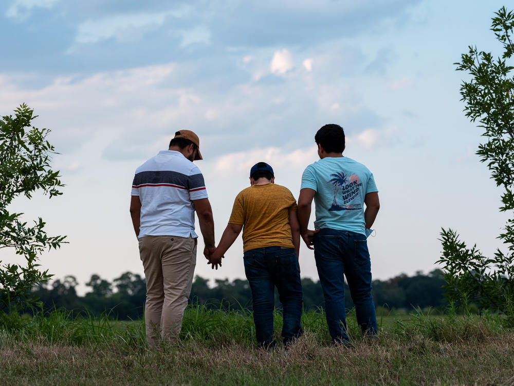 Honduran migrants, Ricardo Sr., (left), his son Ricardo Jr., 13, and his cousin Jorge, 16, walk near their home in Texas. When the two teenage boys crossed the border illegally into Texas last month, they turned themselves in to the Border Patrol. They were later escorted to a hotel by armed men in civilian clothes.