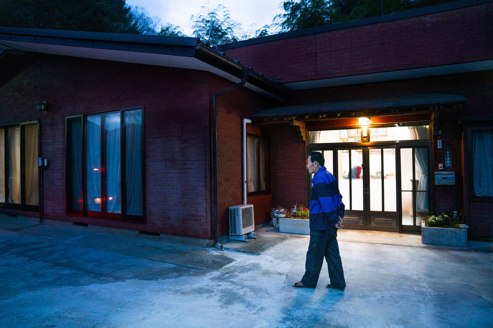 Shuichi Kanno, 79, walks in front of his home at dusk. Kanno has been dealing with hordes of macaque monkeys in his neighborhood in Japan. They frequently wake him up as they climb over his roof in the early morning hours.