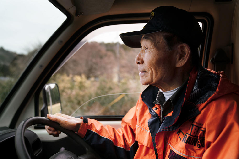 Kanno drives his truck down a main road in his neighborhood, chasing monkeys that he saw scampering around his house not long ago.
