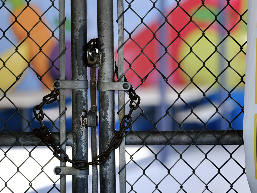A chain-link fence lock is seen on a gate at a closed Ranchito Elementary School in the San Fernando Valley section of Los Angeles on July 13. Amid spiking coronavirus cases, the Los Angeles Unified School District is implementing a testing contact tracing plan.