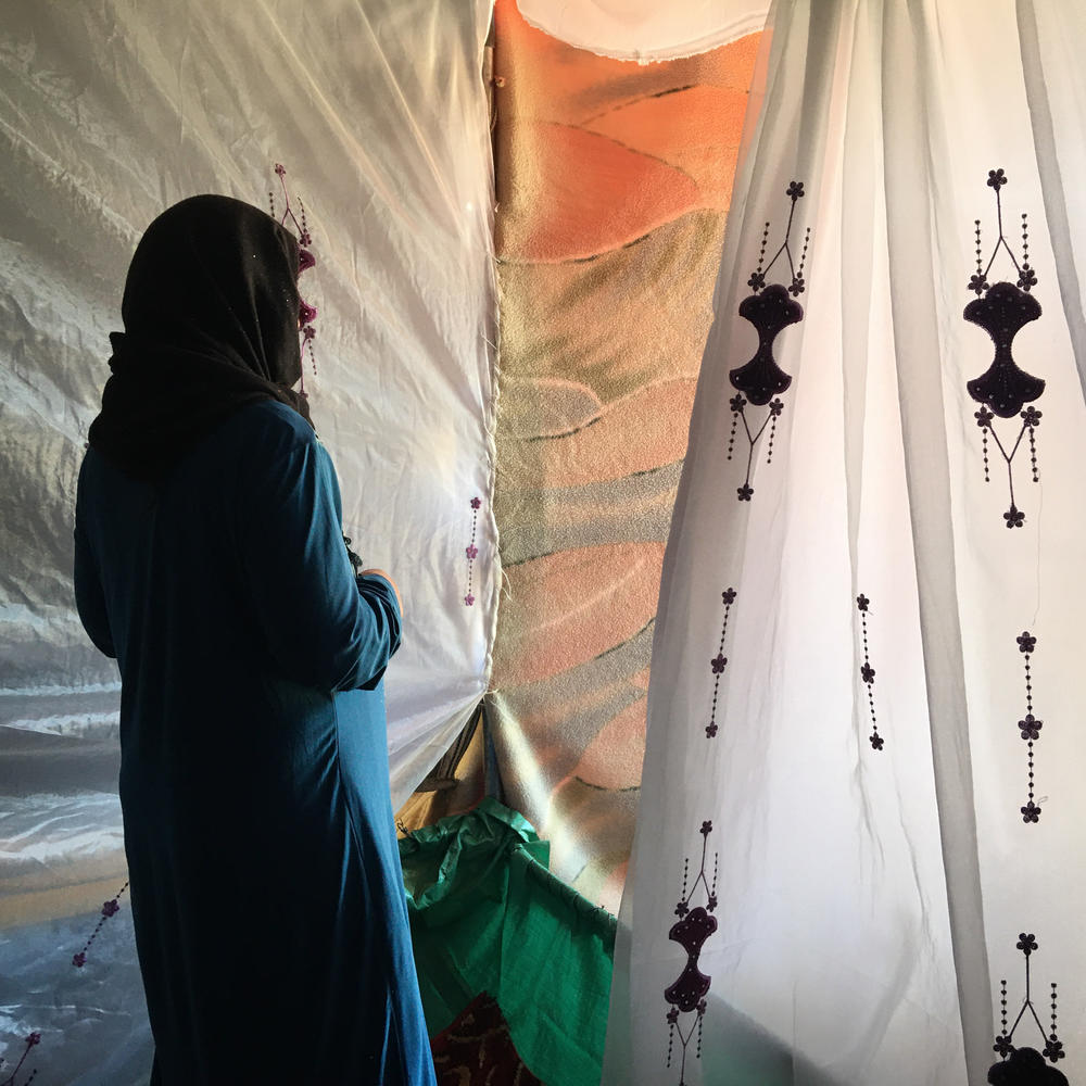 Ftaim al-Saleh stands in the tent donated by friends and relatives after her four youngest children died when their tent caught fire, as she and her husband were working in the fields. The Syrian refugee couple came to Jordan eight years ago, after airstrikes destroyed their house.