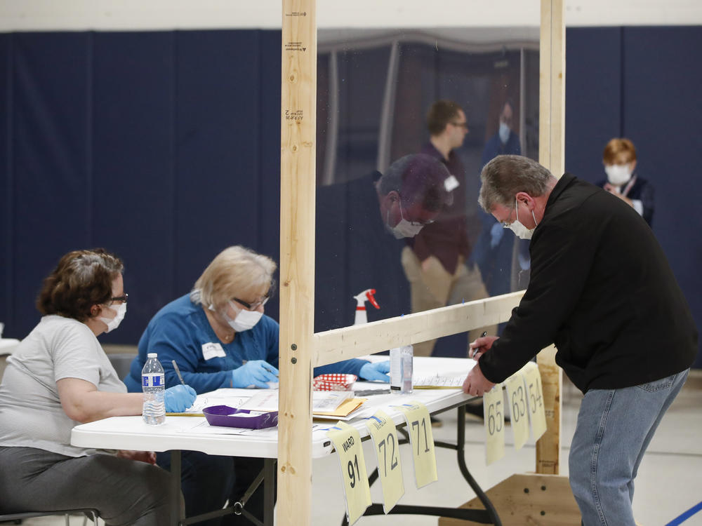 A man checks to cast his ballot in Kenosha, Wis., on April 7. A new study suggests that in-person voting in that Wisconsin primary did not produce a surge of new coronavirus cases.