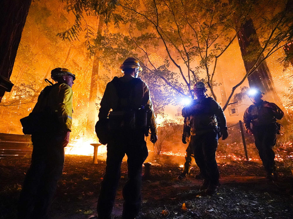 Firefighters make a stand in the backyard of a home in front of the advancing C.Z.U. Lightning Complex fire on Friday. California is seeing some of the worst first in the state's history.
