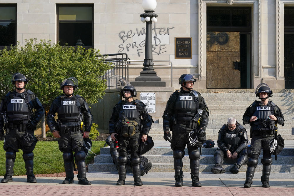 Police in riot gear stand outside the Kenosha County Courthouse on Monday in Kenosha.