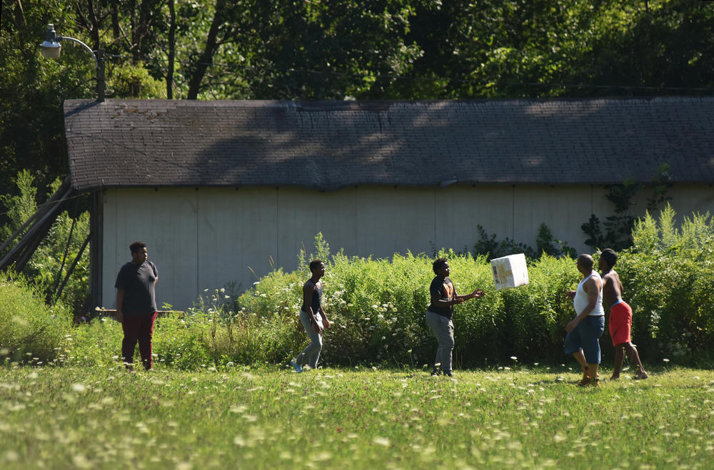 Members of James Minton's family help deliver a package of chicken bedding to the coops at the Triple J Farm.