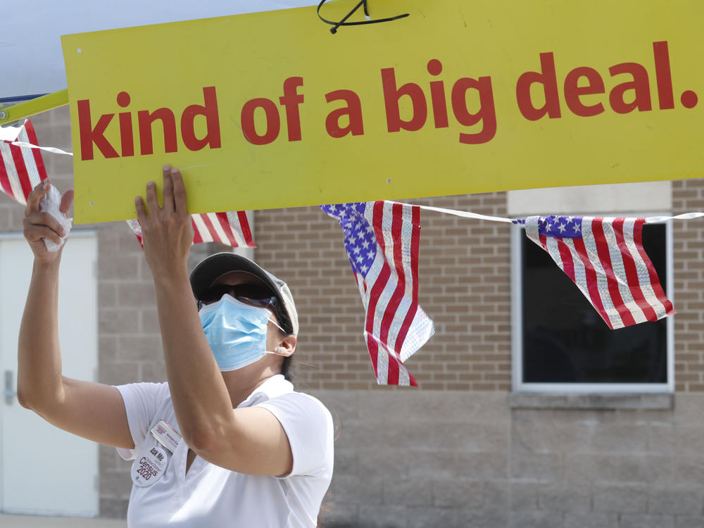 U.S. Census Bureau worker Marisela Gonzales adjusts a sign at a walk-up counting site for the 2020 census in Greenville, Texas, in July.