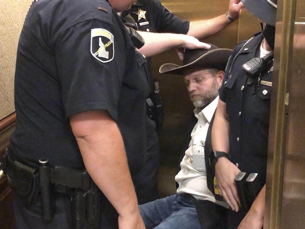 After he refused to stand when asked, anti-government activist Ammon Bundy was wheeled into an elevator in a chair, following his arrest at the Idaho Statehouse in Boise on Tuesday.