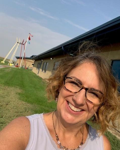 Pam Gunner outside the school she will soon be teaching at on the Pine Ridge Reservation. She feels lucky to have found the job amid the pandemic and has been staving off eviction until she starts getting paid again.