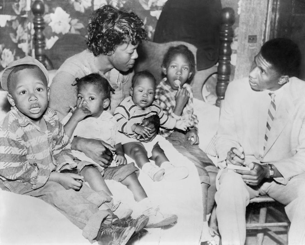 Beulah Melton, widow of Clinton Melton, speaks with NAACP field secretary Medgar Evers in 1955. She holds her four children including 5-year-old Deloris (right).