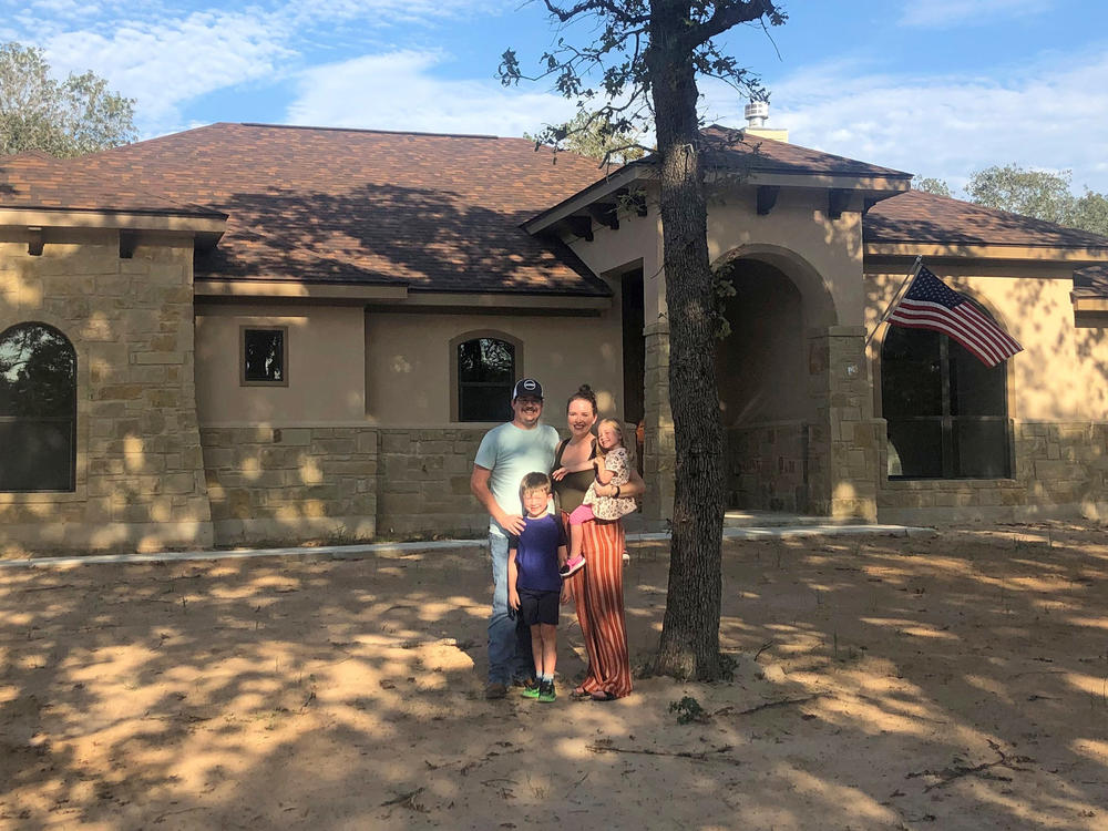 Caroline Wells and her family at their new home outside San Antonio. The builders just finished it so the yard has yet to be planted, but the couple are looking forward to letting the kids run out their energy with a lot more outdoor space than they had at their home in the city.