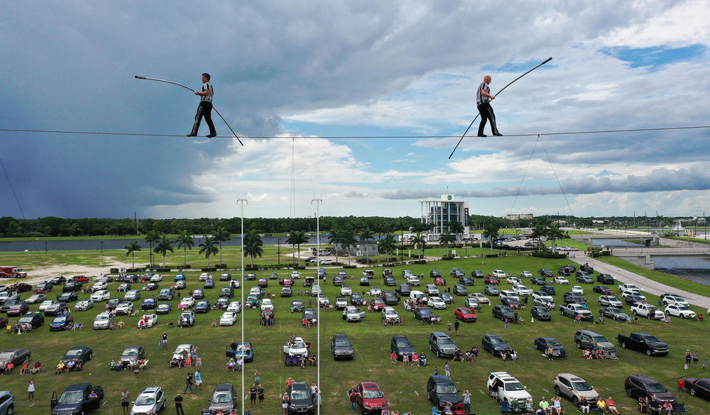 People parked their cars outside in a distanced tailgater in June to watch high-wire artists and cousins Nik (left) and Blake Wallenda perform at Nik Wallenda's Daredevil Rally, billed as the world's first drive-in stunt show at Nathan Benderson Park in Sarasota, Fla.
