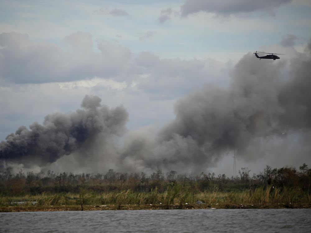 A helicopter flies over a chemical fire at BioLab plant after Hurricane Laura made landfall in Westlake, La., on Aug. 27, 2020.