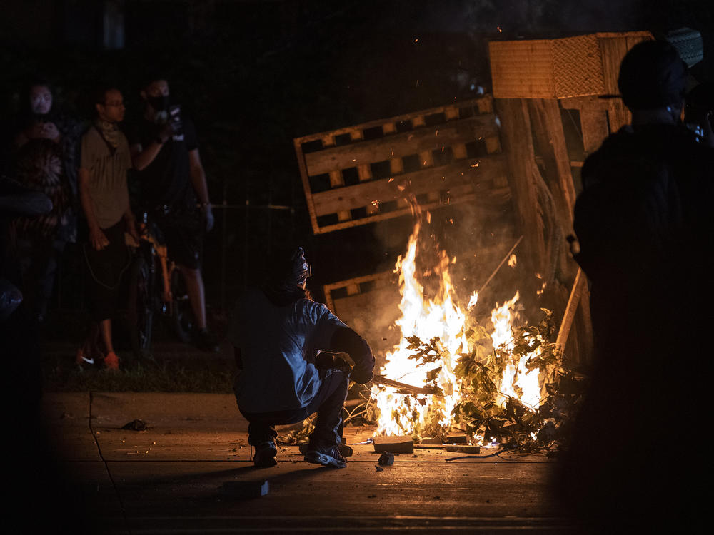 A protester in Kenosha lights some debris on fire on Aug. 26, 2020.