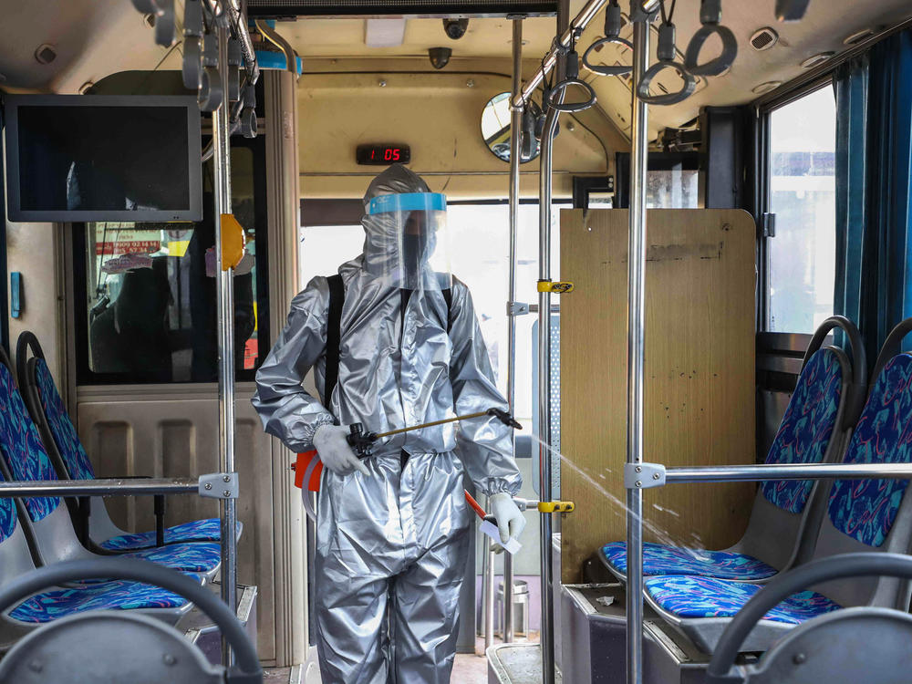 A worker disinfects the inside of a bus in Addis Ababa, Ethiopia. Transit agencies are taking new steps to reduce the risks for riders during the pandemic.