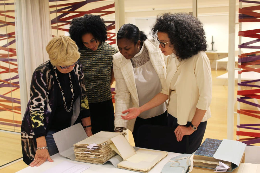 Valika Smeulders (far right), head of history at Amsterdam's Rijksmuseum, explains what is included in a stack of colonial documents at the National Archives in The Hague to (right to left) Peggy Bouva, Jessica Bouva and Maartje Duin's mother Albertin Duin-van Lynden.