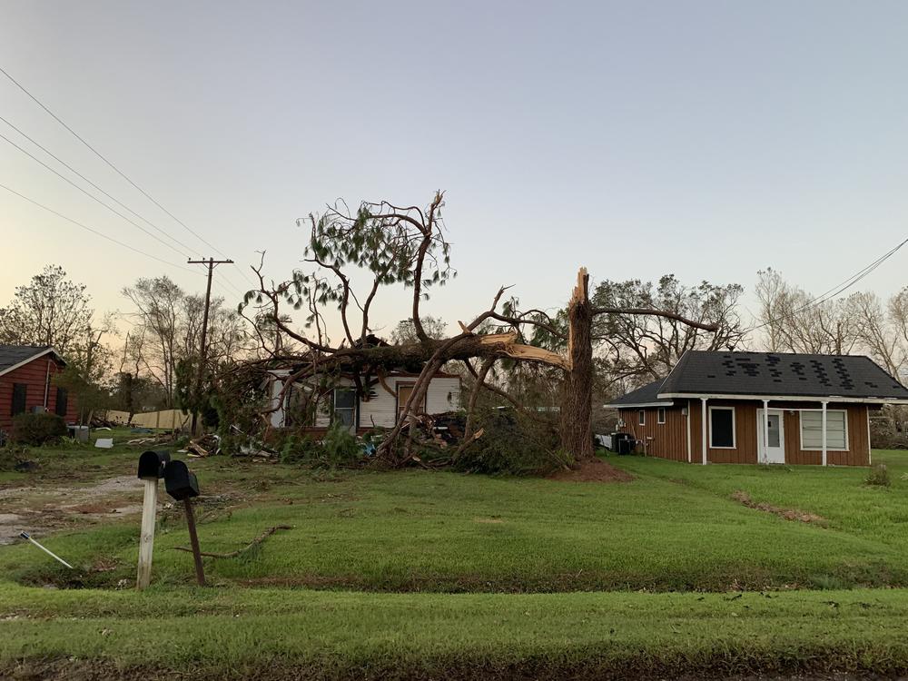 A home near Iowa, La., was crushed by a snapped tree after Hurricane Laura made landfall with 150 mph winds Thursday. The area is facing two disasters at once.