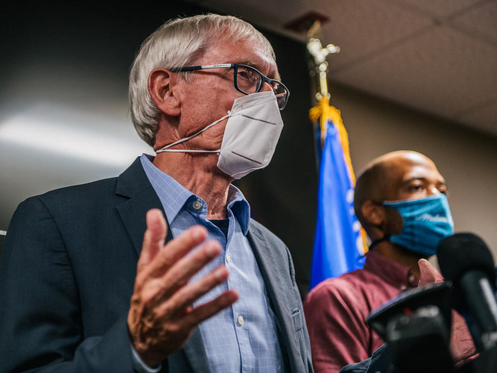 Wisconsin Gov. Tony Evers (left) speaks at a news conference held Thursday in Kenosha, Wis., to discuss recent civil unrest surrounding the police shooting of Jacob Blake, a Black man who was shot several times in the back in front of his children.