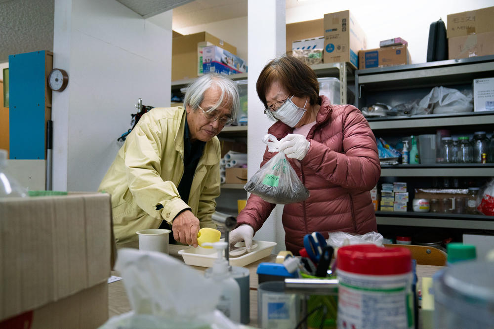 Takenori Kobayashi (left) and his wife Tomoko Kobayashi bring soil samples into what they refer to as a 