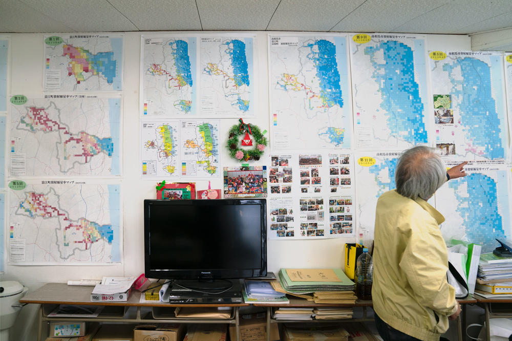 Maps hang on the wall of the lab where the Kobayashis do radiation testing. The maps, one part of their work, were created by a team of volunteers who took air measurements. The maps show that the radiation levels in Fukushima are decreasing.
