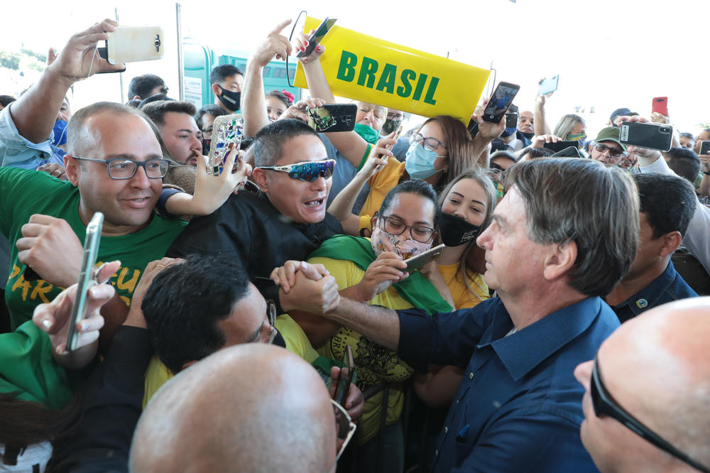 Brazilian President Jair Bolsonaro stops to take pictures with supporters during the inauguration ceremony of the BR-469 highway development on Aug. 27 in Foz do Iguaçu, Brazil.
