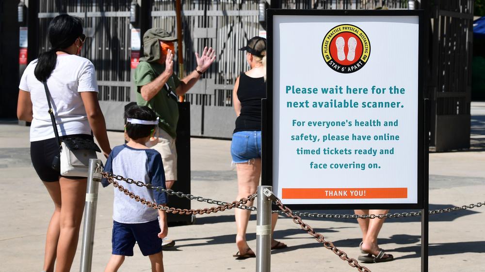 Visitors are reminded of social distancing guidelines while entering the Los Angeles Zoo, which reopened last week after shutting down in mid-March due to the coronavirus pandemic.
