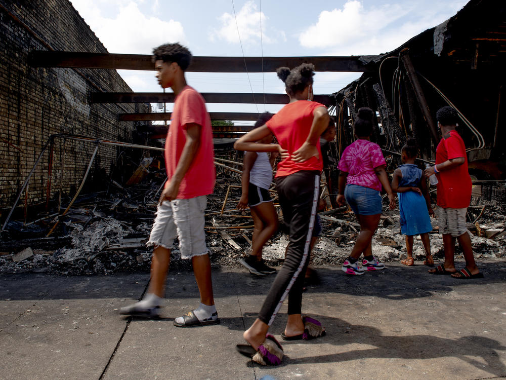 People pass by a destroyed building in Kenosha, WI.