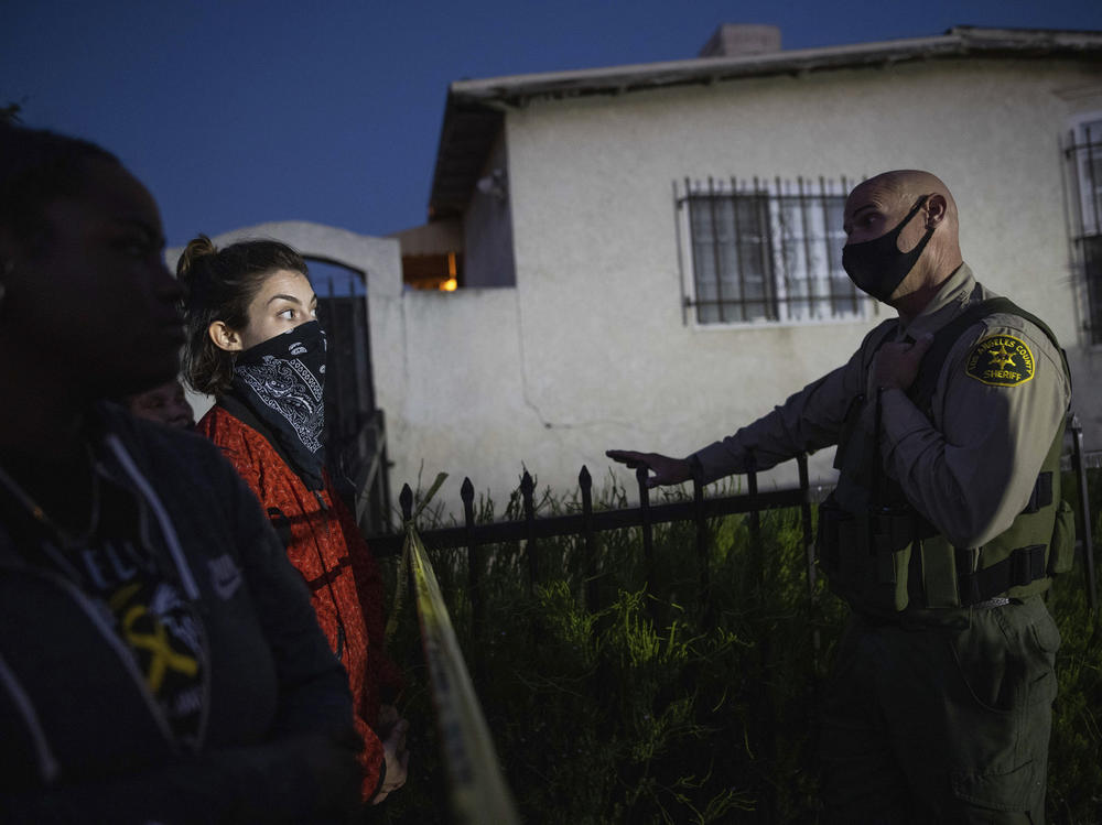 A protester talks with a deputy of the Los Angeles Sheriff's Department during demonstrations following the death of a Black man identified as Dijon Kizzee on Monday in Los Angeles.