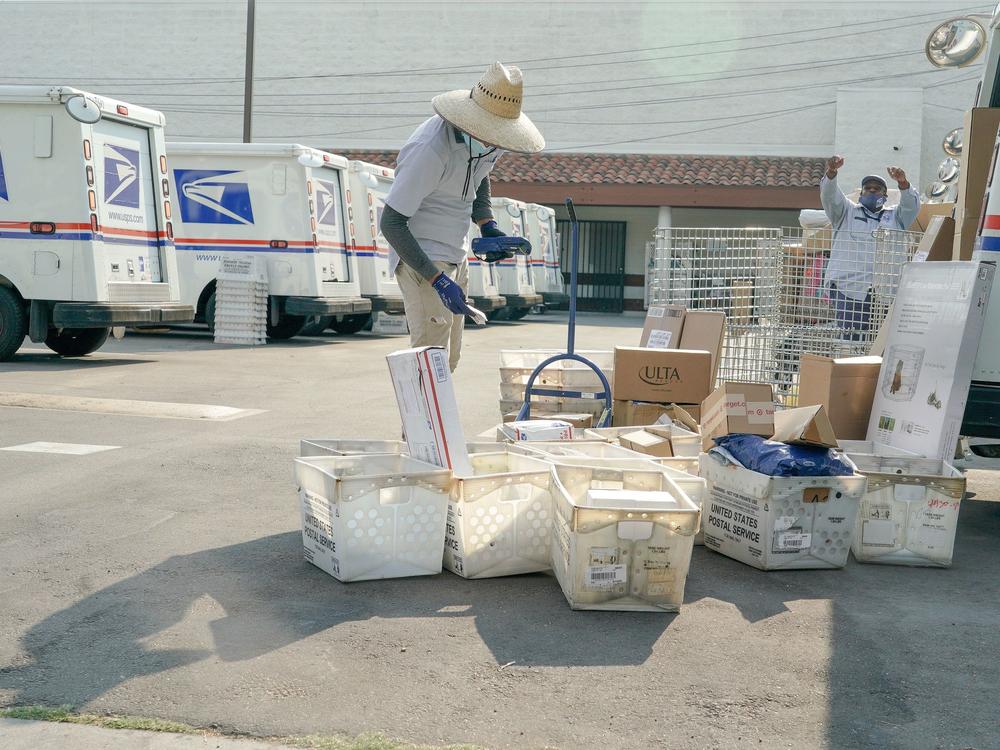 Postal workers sort, load and deliver mail at a U.S. Postal Service location last month in Los Angeles.