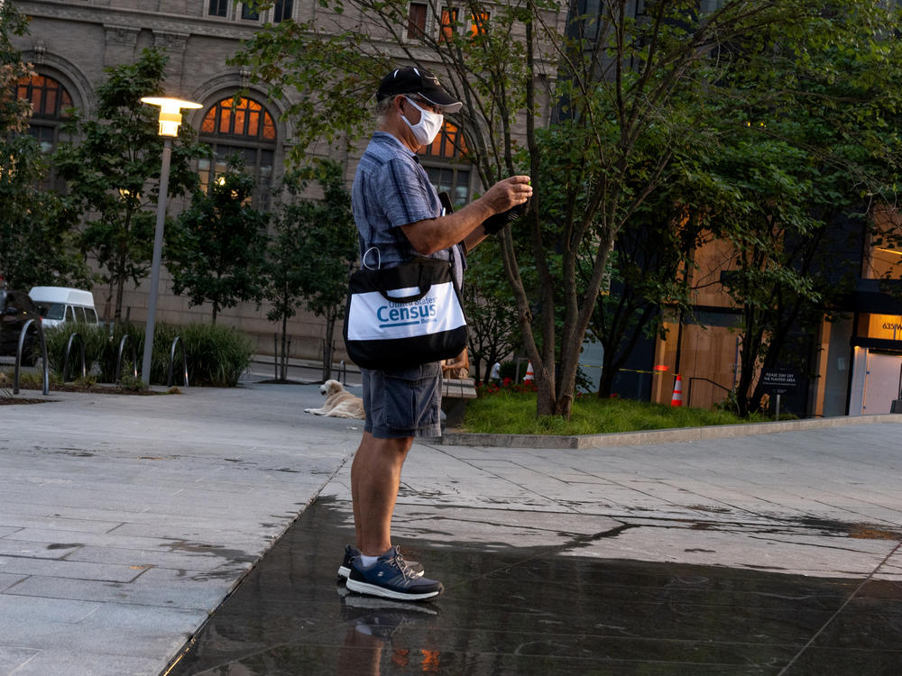 A Census Bureau worker with a face covering stands in a park in New York City in August. The bureau confirmed on Tuesday that door knocking is ending in some areas earlier than Sept. 30.