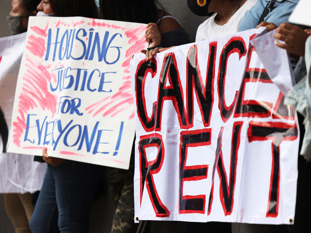 Demonstrators hold up signs as they gather at Brooklyn Housing court during a 'No Evictions, No Police' national day of action in New York City.