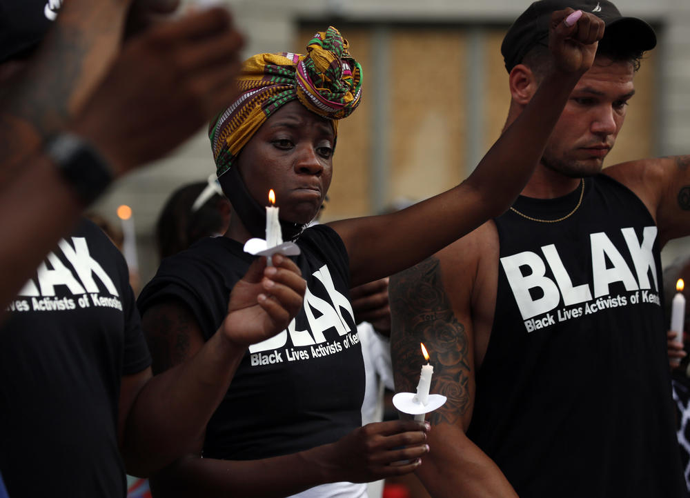 Members of Black Lives Activist of Kenosha Porche Bennett and Nick Larsen react as they participate in a candle light vigil in Kenosha, Wisconsin, Friday, August 28.