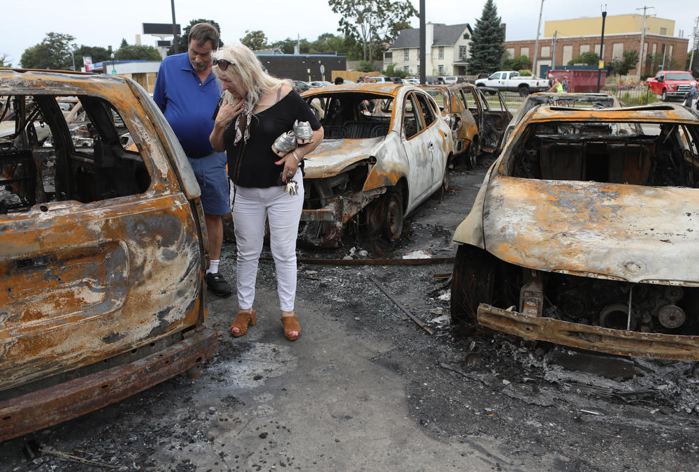 People survey the damage at a used car lot in Kenosha, Wisconsin.