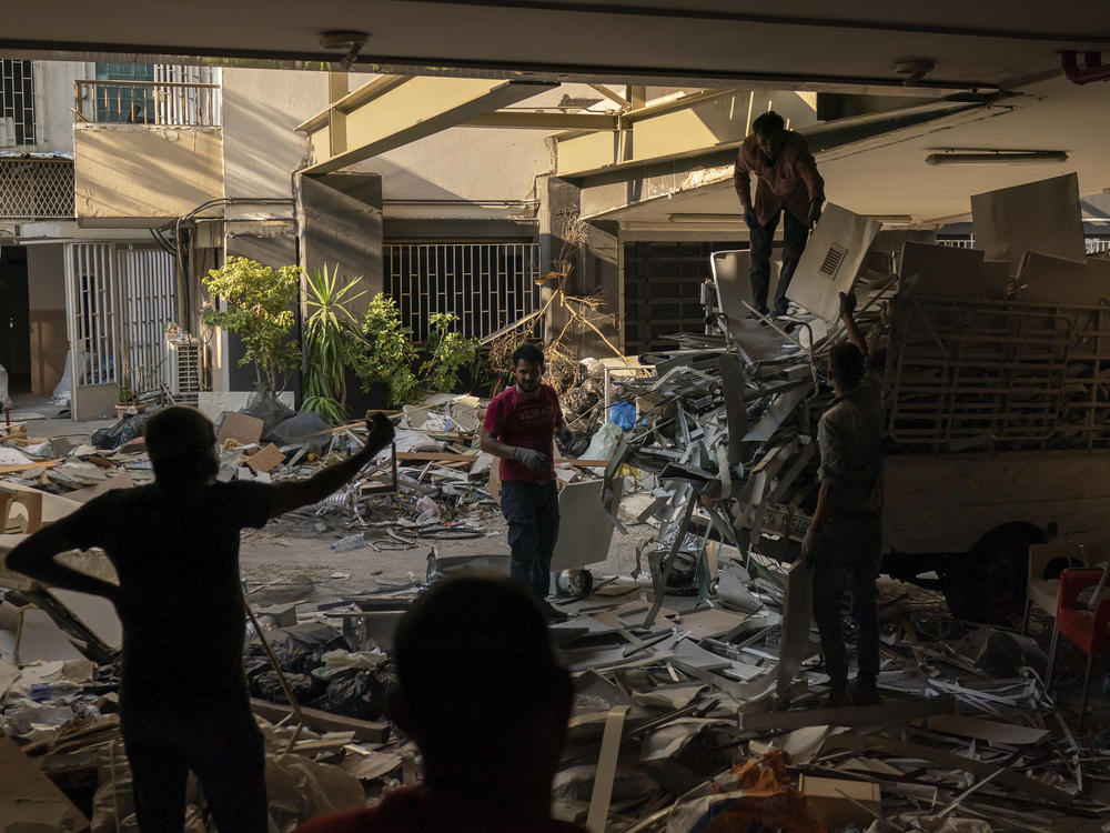 Workers remove debris from a hospital that was heavily damaged in last month's explosion in Beirut. Lebanon's interim health minister, Hamad Hasan, told local media last month that the health system was 